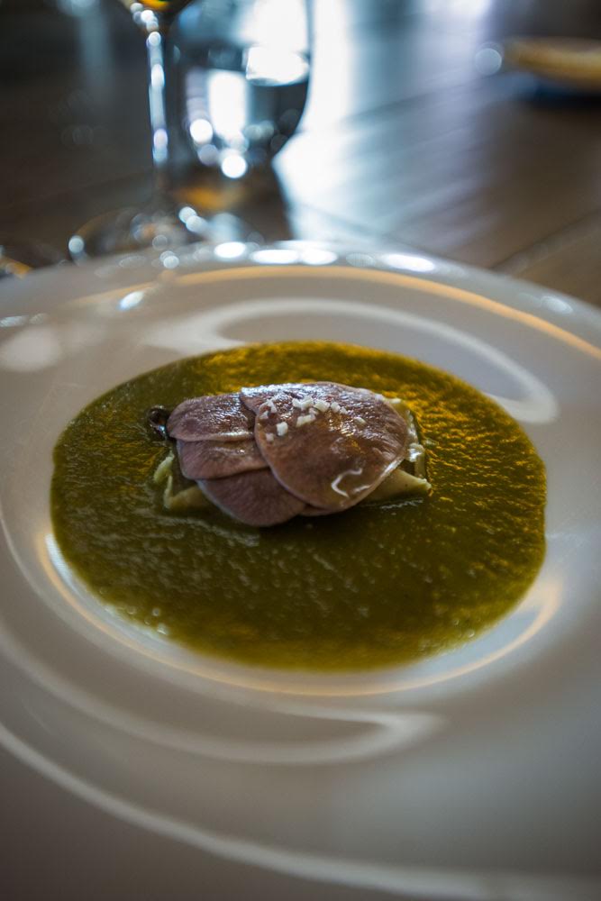 Tamalito de frijol con lengua de res y mole verde.