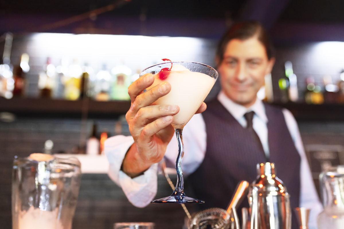Bartender offering a piña colada