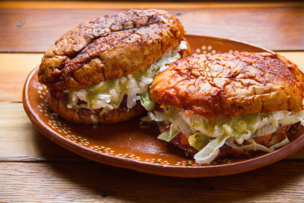Los pambazos chilangos llevan un pan adobado y relleno de papa con chorizo, frijoles y más