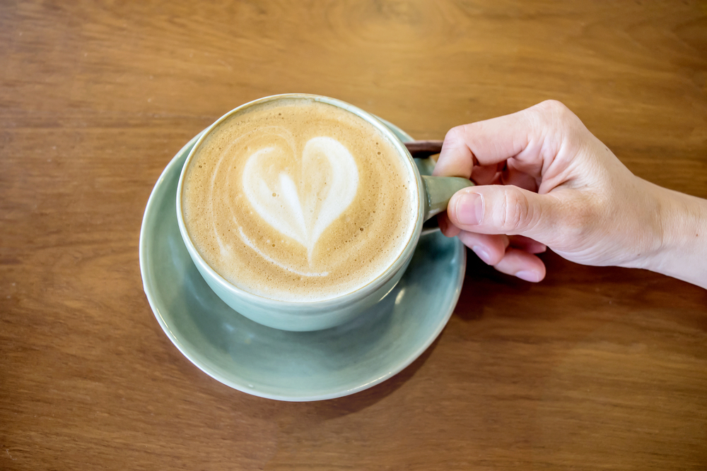 Mujer sosteniendo una taza de café capuchino