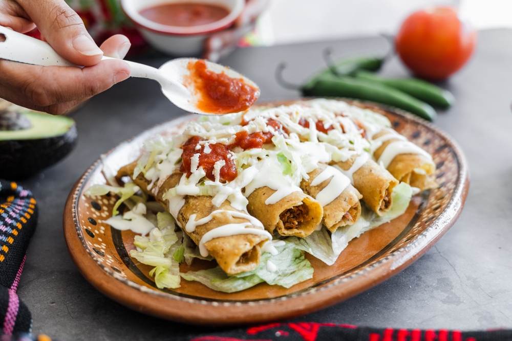 Plato con tacos dorados de pollo y salsa
