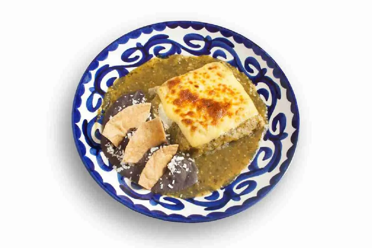 Tamal costeño verde en hoja de plátano con salsa verde y pollo. 