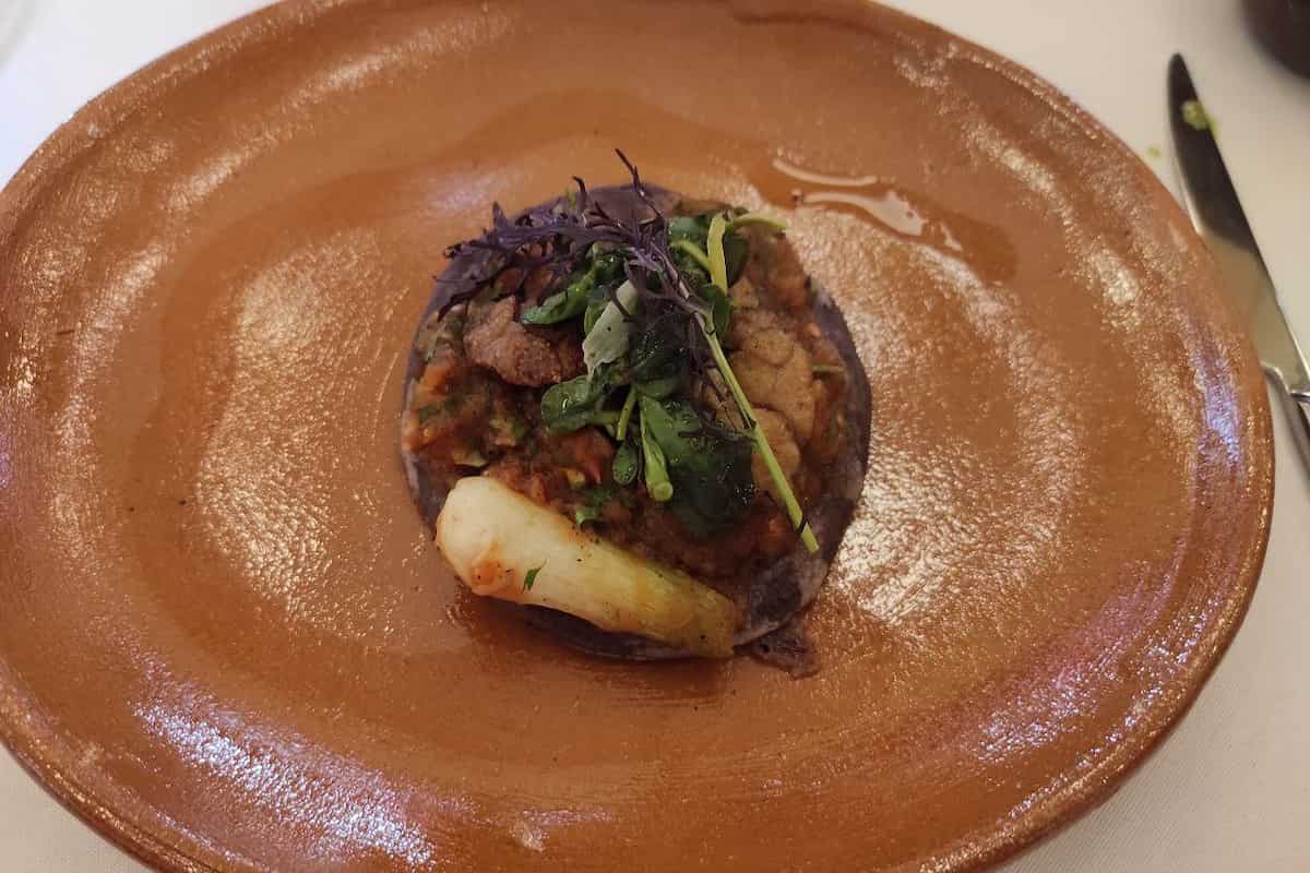 Tlacoyo de maíz azul con mollejas a las brasas.