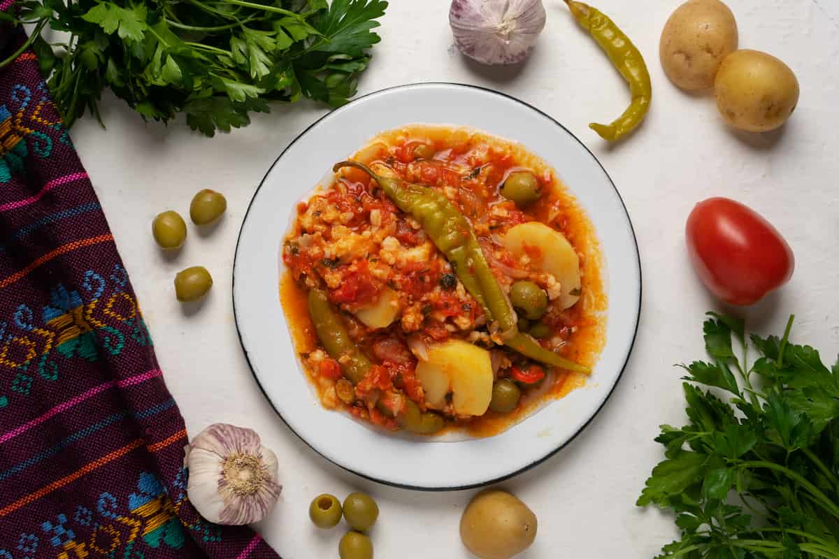 los ingredientes típicos del bacalao navideño son bacalao, alcaparras, aceitunas, chiles güeros, tomate, papa, cebolla, ajo y almendras