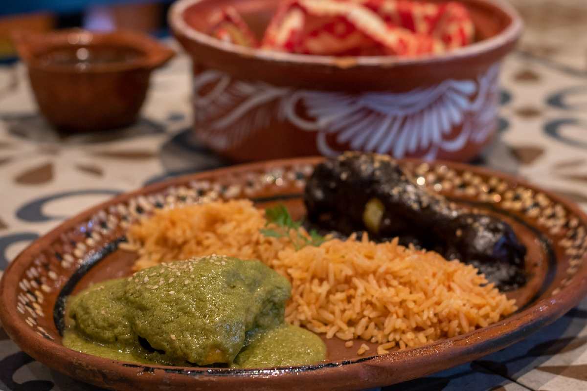 Pollo con mole y pipián acompañado de arroz rojo.