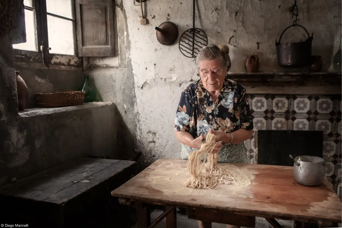 Mujer anciana preparando pasta tradicional italiana