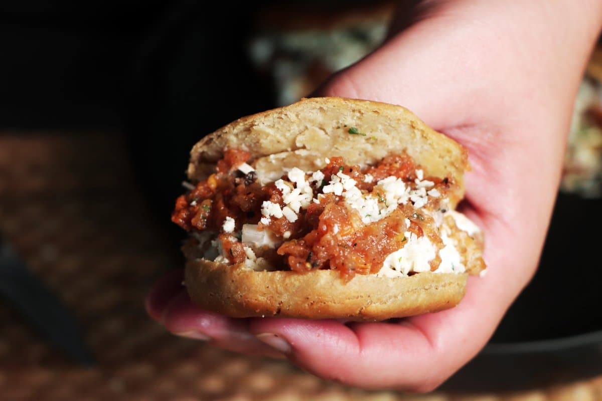Una mano mostrando una gordita de chicharrón preparada