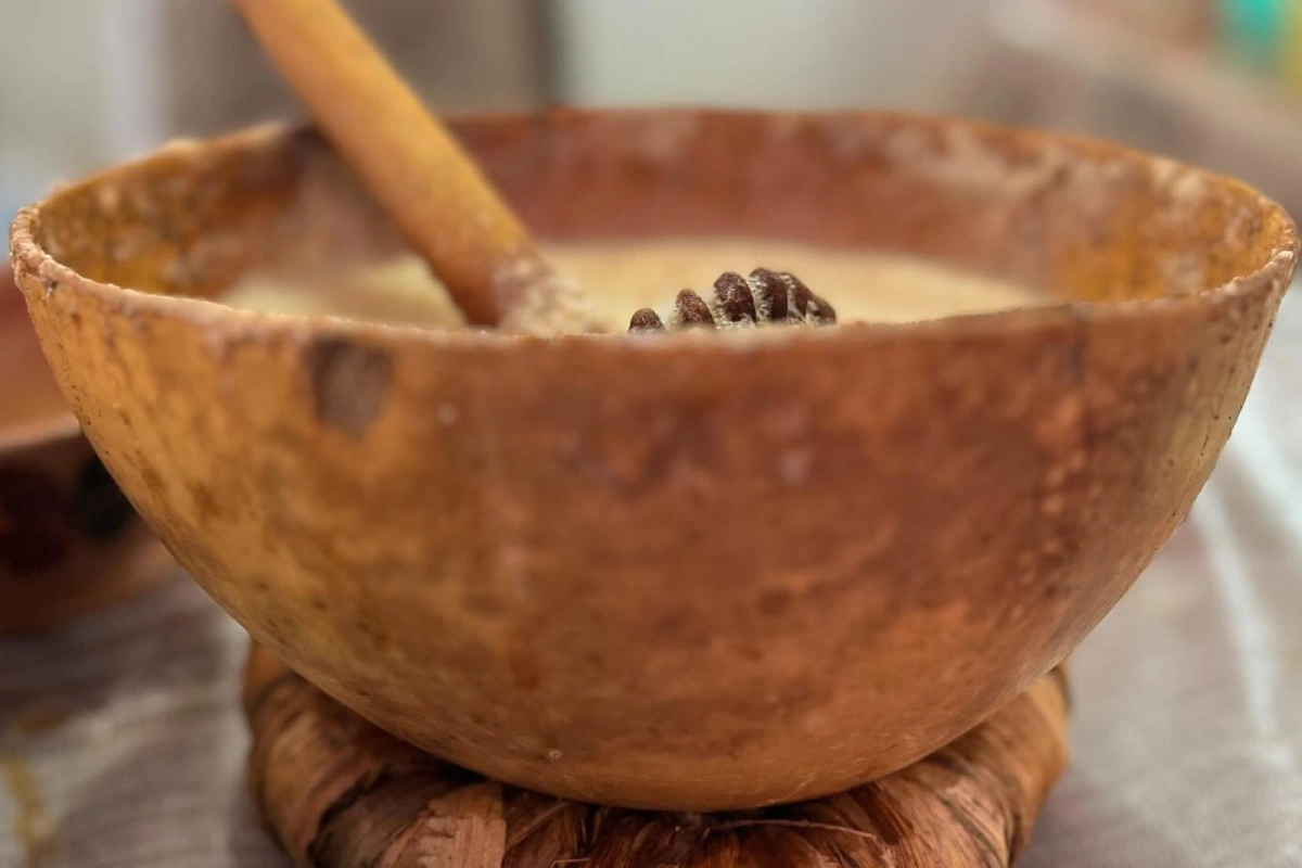 Jícara de barro con un molinillo que contiene el pozontle, bebida a base de cacao típica de Oaxaca.