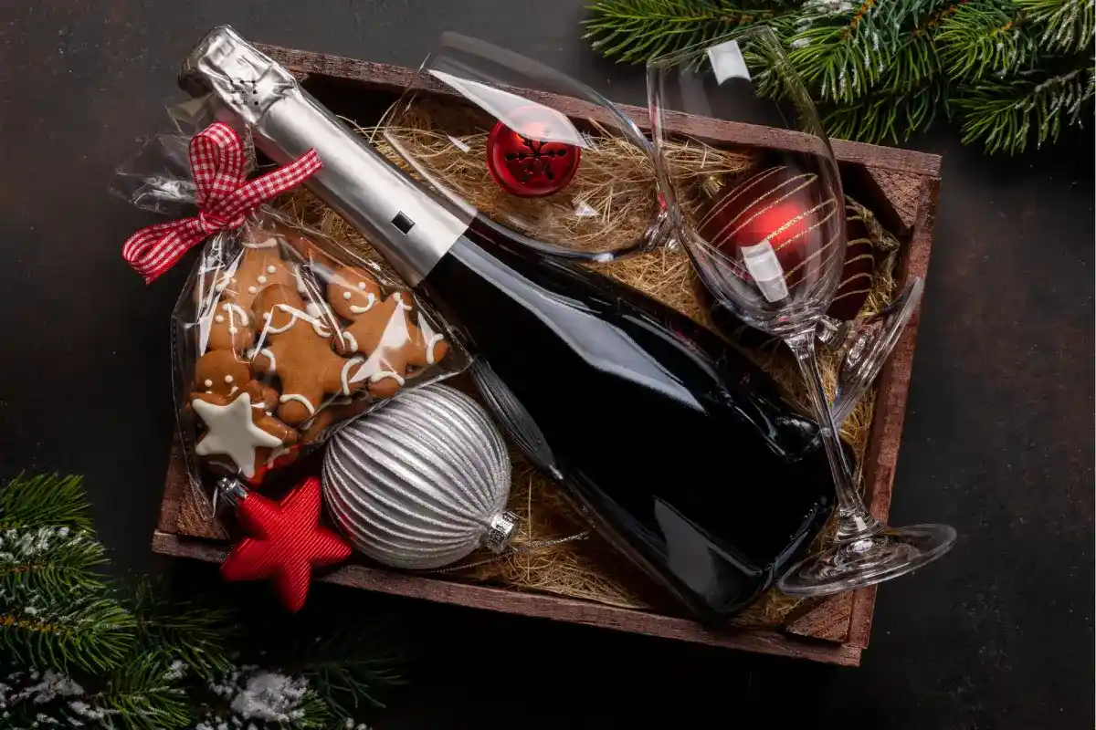 canasta navideña con vino, galletas y decoraciones