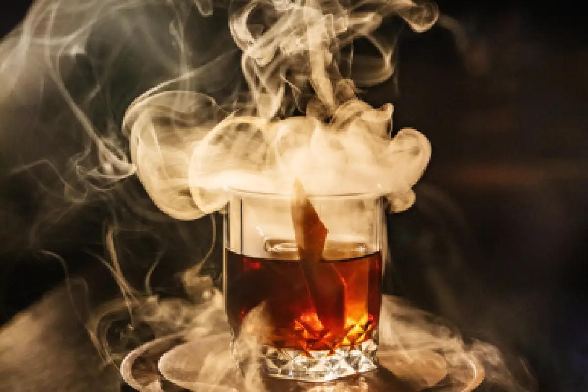 vaso old fashion con coctel y humo