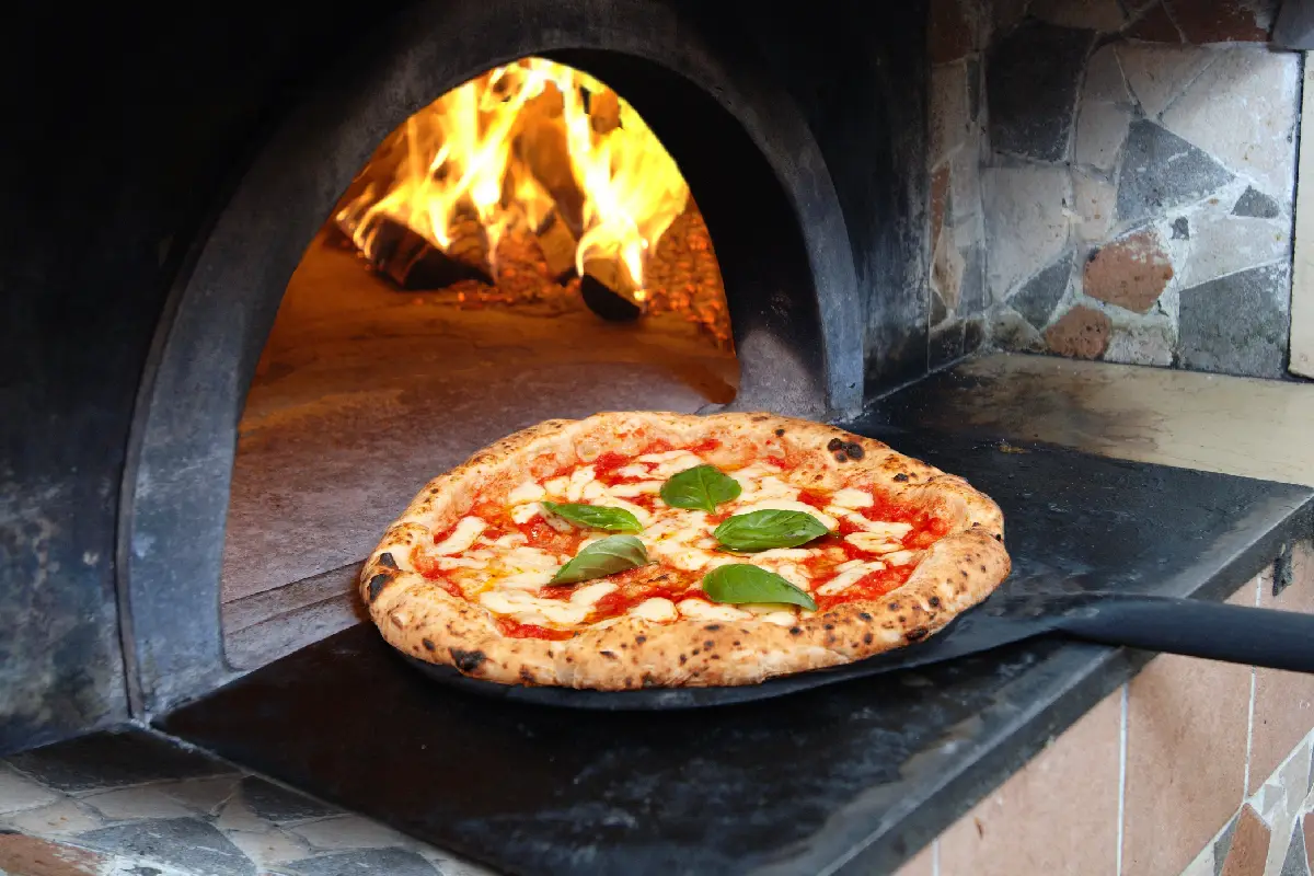Una pizza Margarita es metida a un horno de piedra 