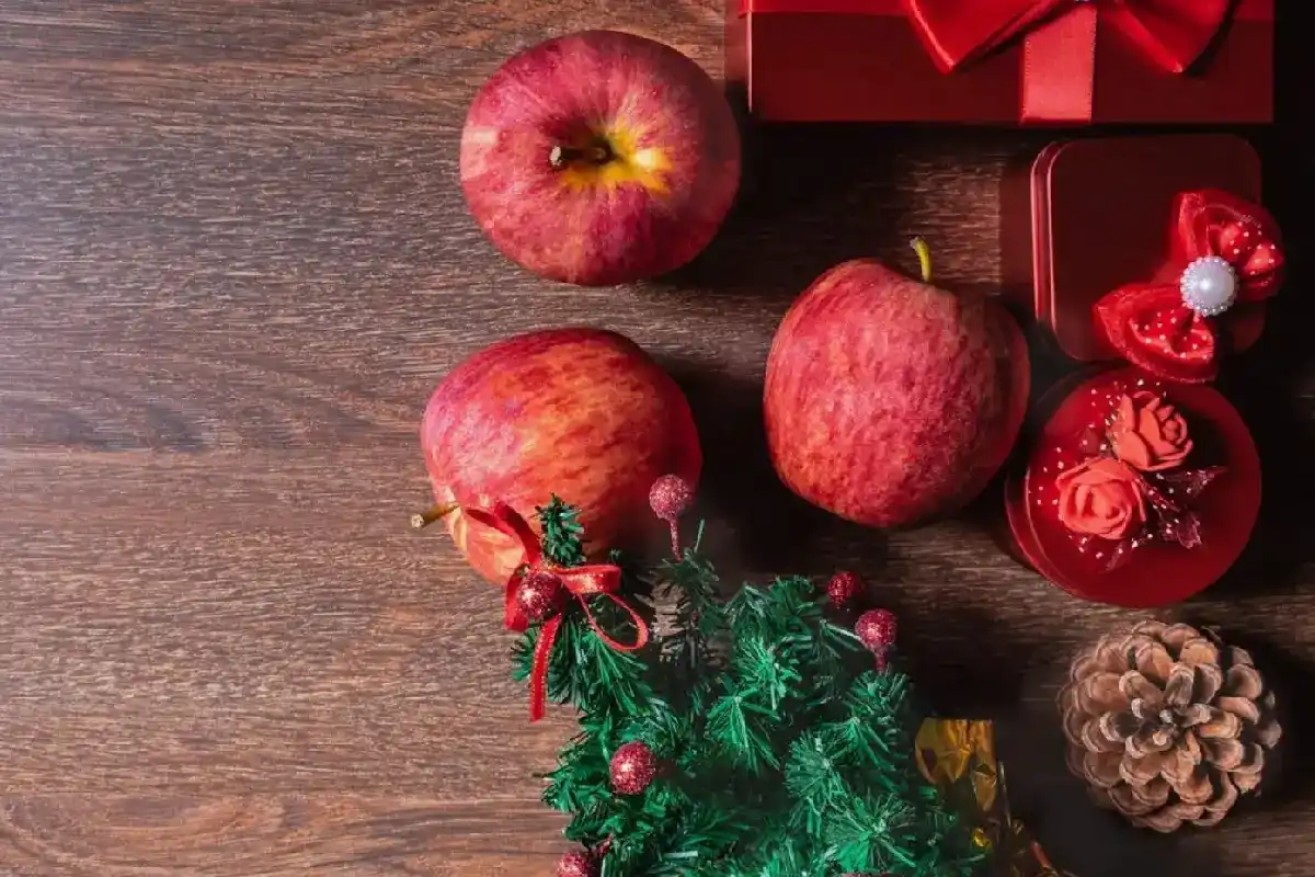 mesa con manzanas y adornos navideños