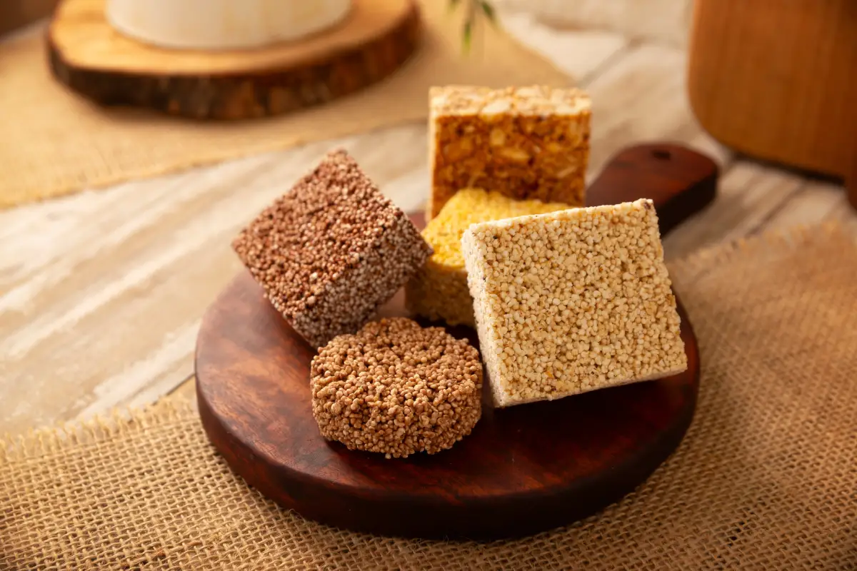 En una tabla de madera hay muestras de alegría con amaranto de diferentes sabores