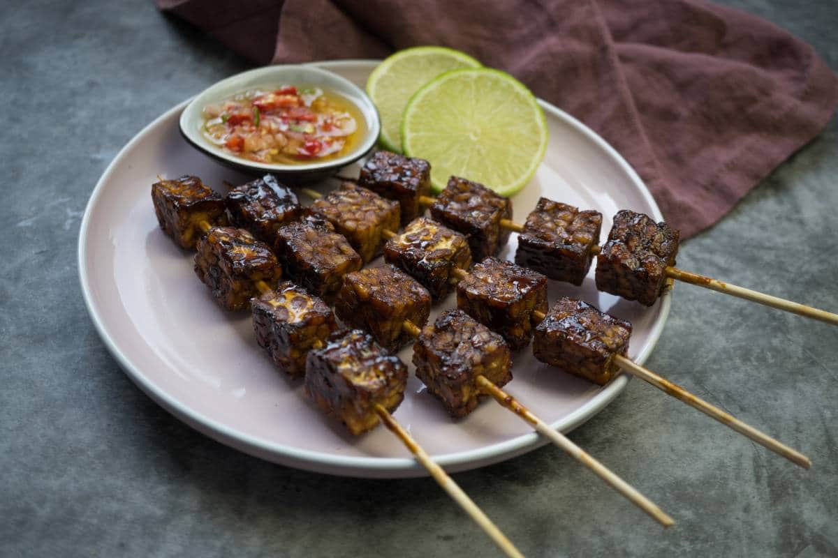 Brochetas de Tempeh presentadas en plato para compartir.