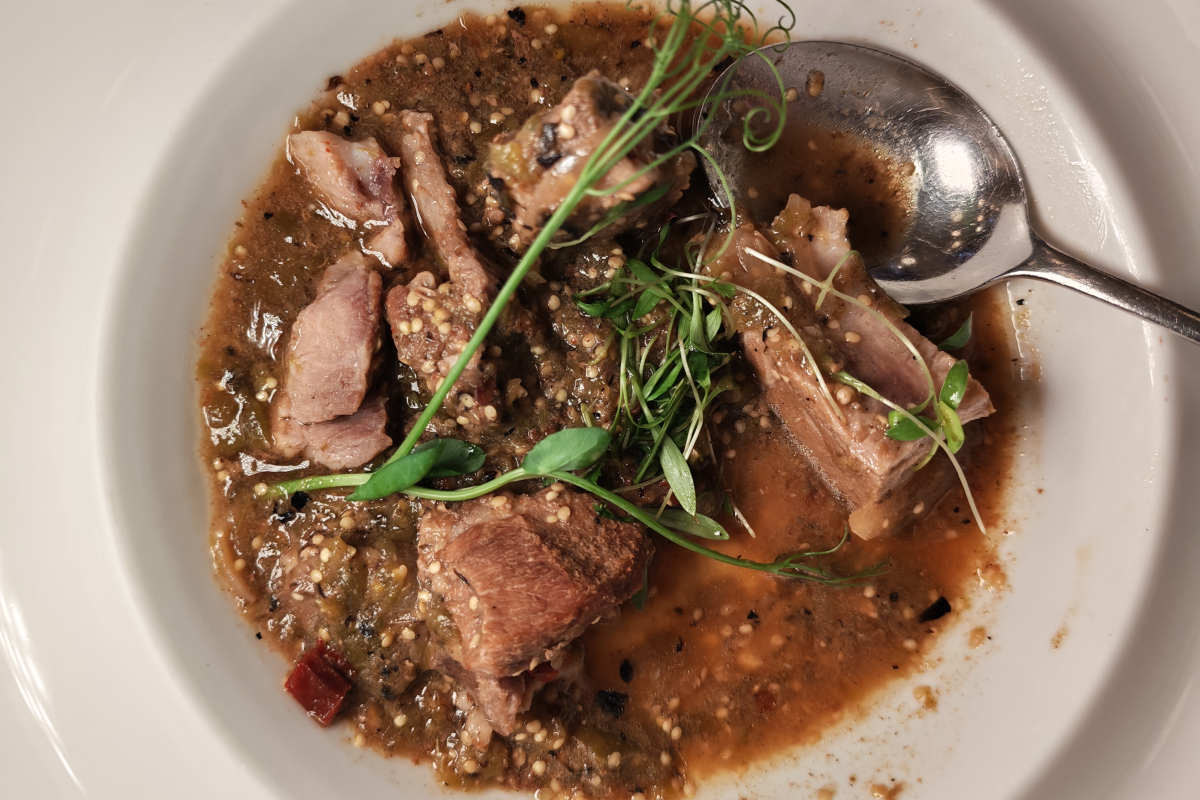 entomatado de puerco con pulque en plato con cuchara