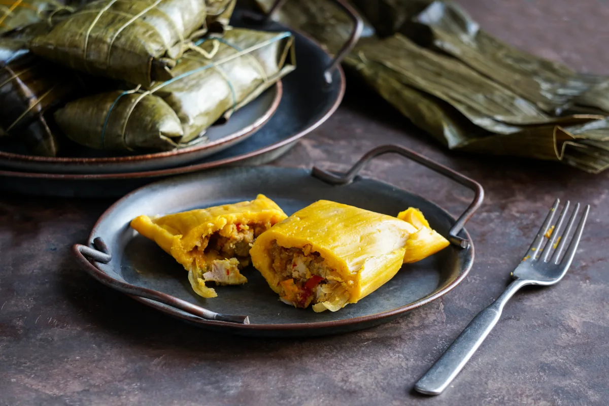 En un plato que está en una mesa hay hallacas, una variedad de tamal​​​​ típica de Venezuela.