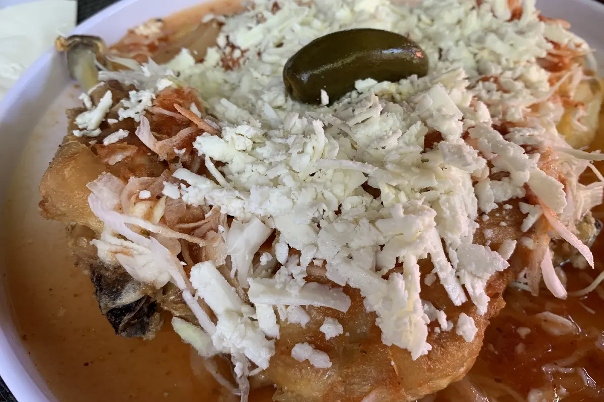 Sobre un plato se encuentra el pollo a la picha, un platillo emblemático de Ixtlán del Río, Nayarit