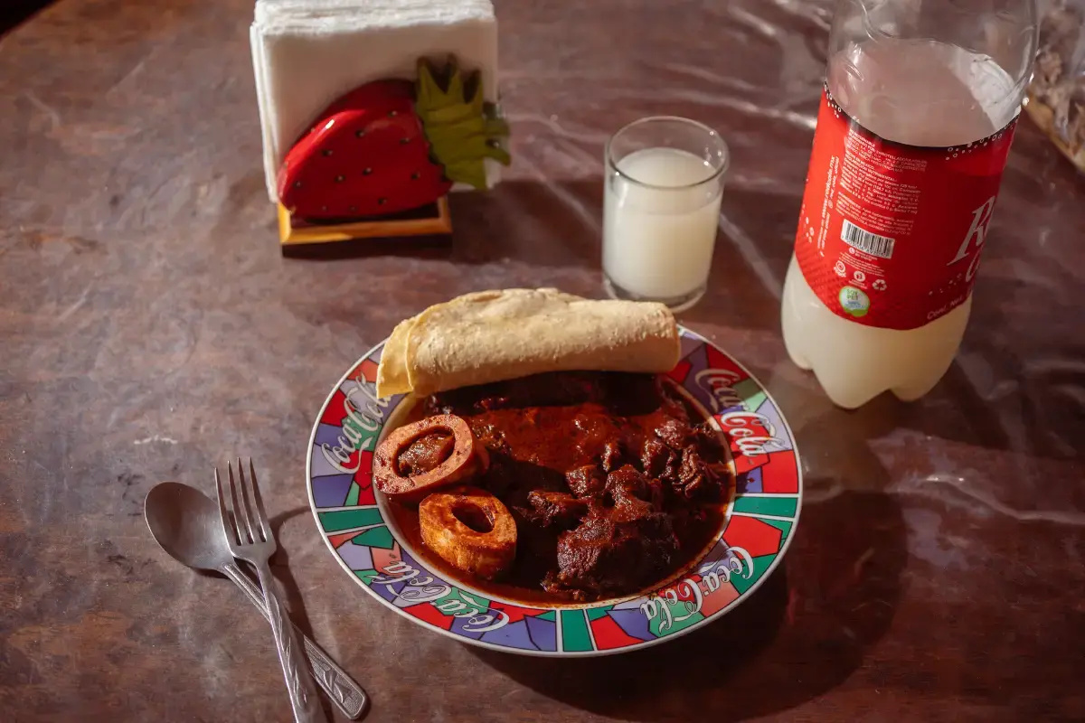 mesa con guiso y vaso de pulque