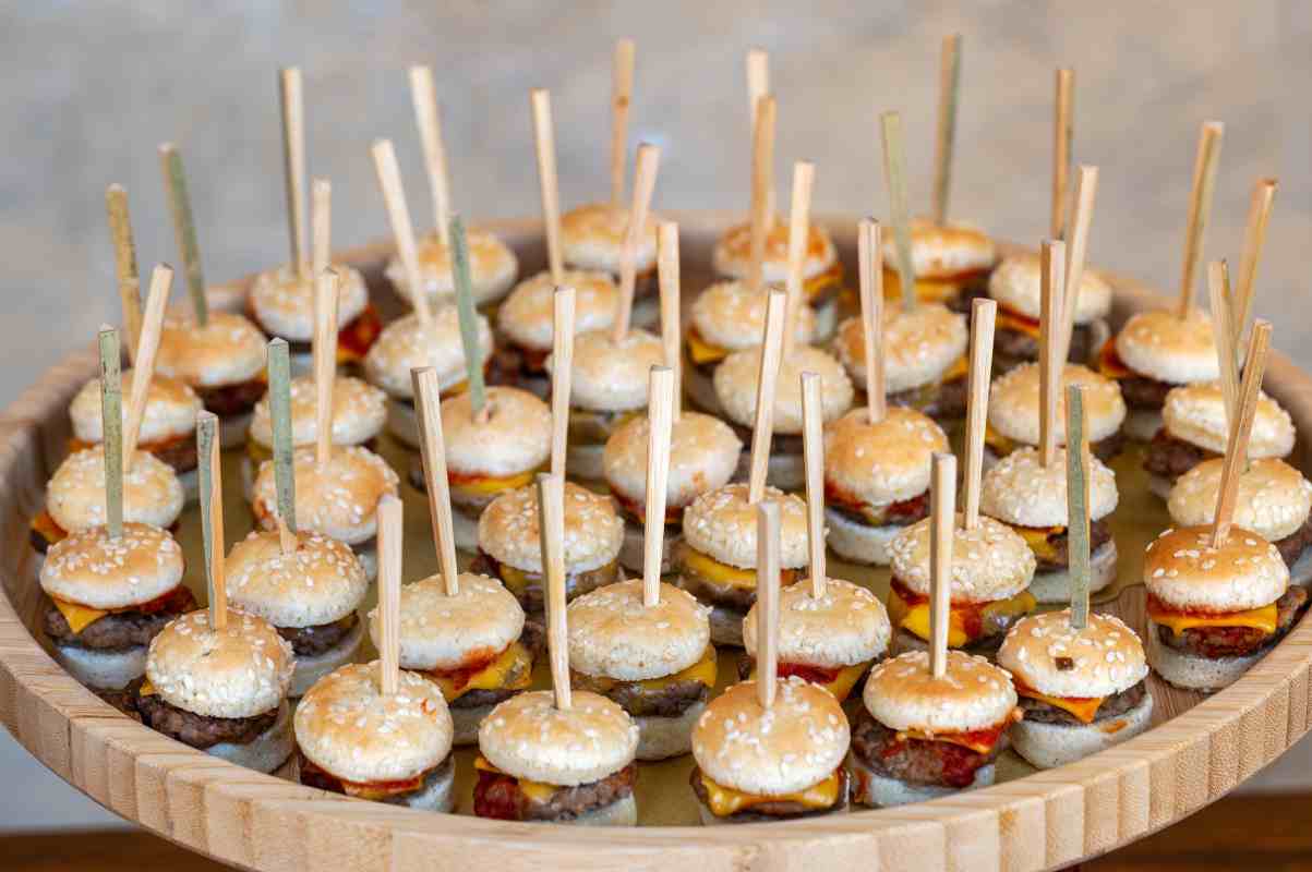 Mini hamburguesas colocadas en charola, para botanear.