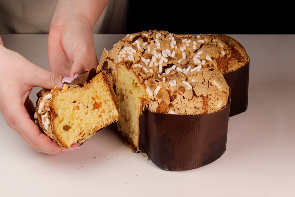 Persona cortando un trozo de pan.