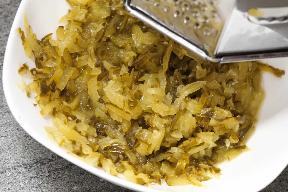 Pepinillos en vinagre siendo cortados.