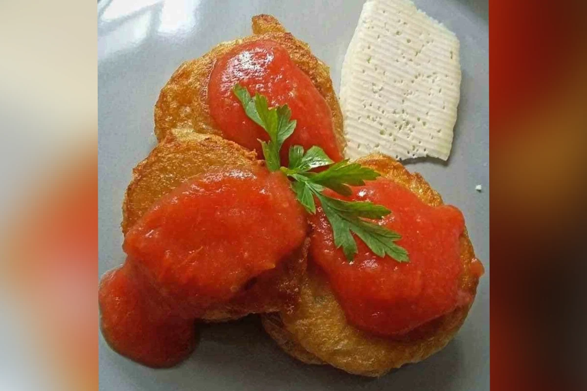 Chinchayotes rellenos de queso y capeados servidos en salsa de jitomate.