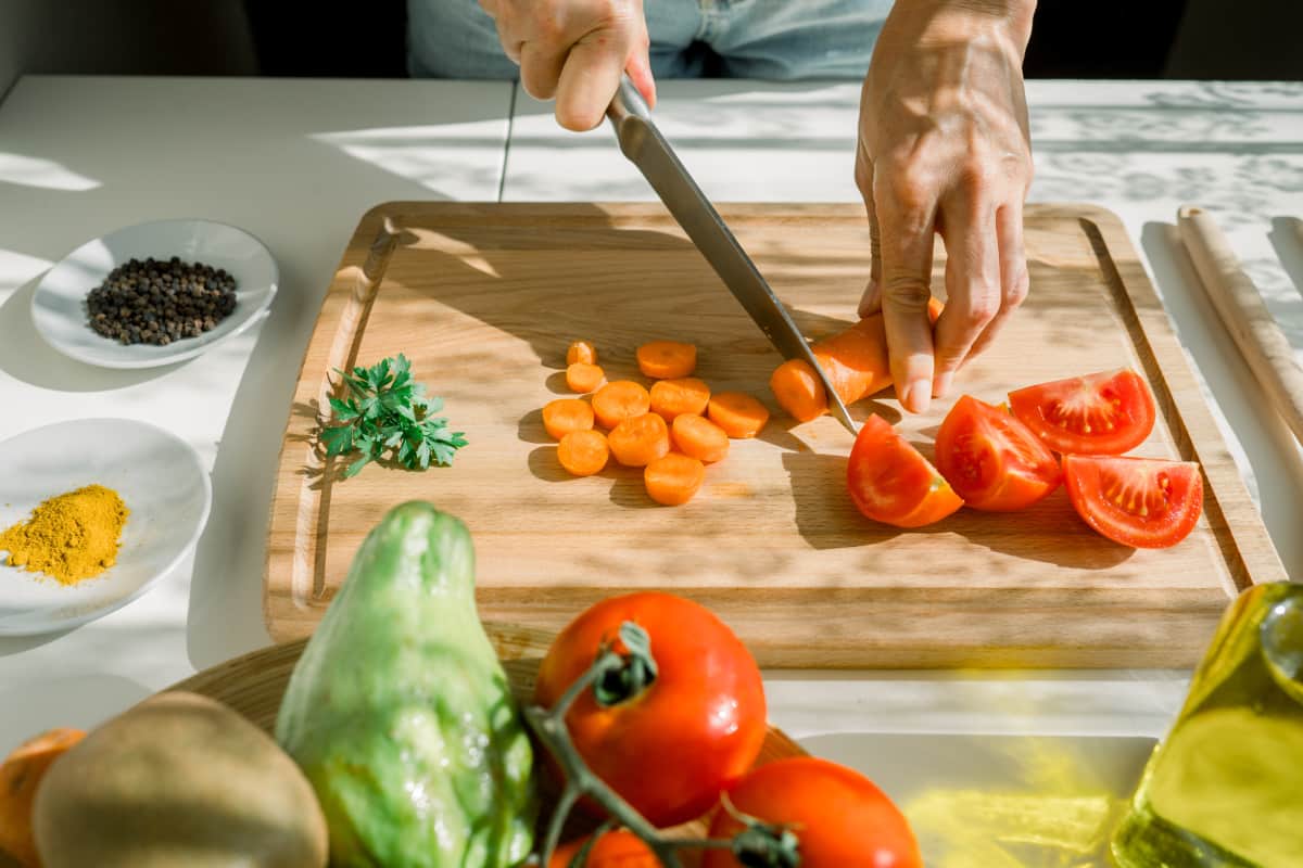 Persona cortando verduras para preparación del Chupe de Camarón.