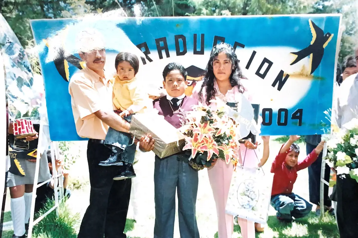 Familia posa para una foto en la graduación de su hijo.