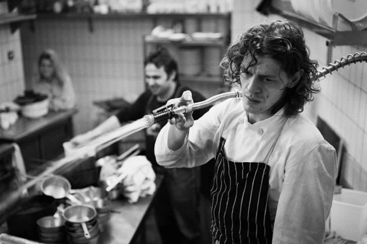 Al interior de una cocina se encuentra un cocinero con cara de cansancio.