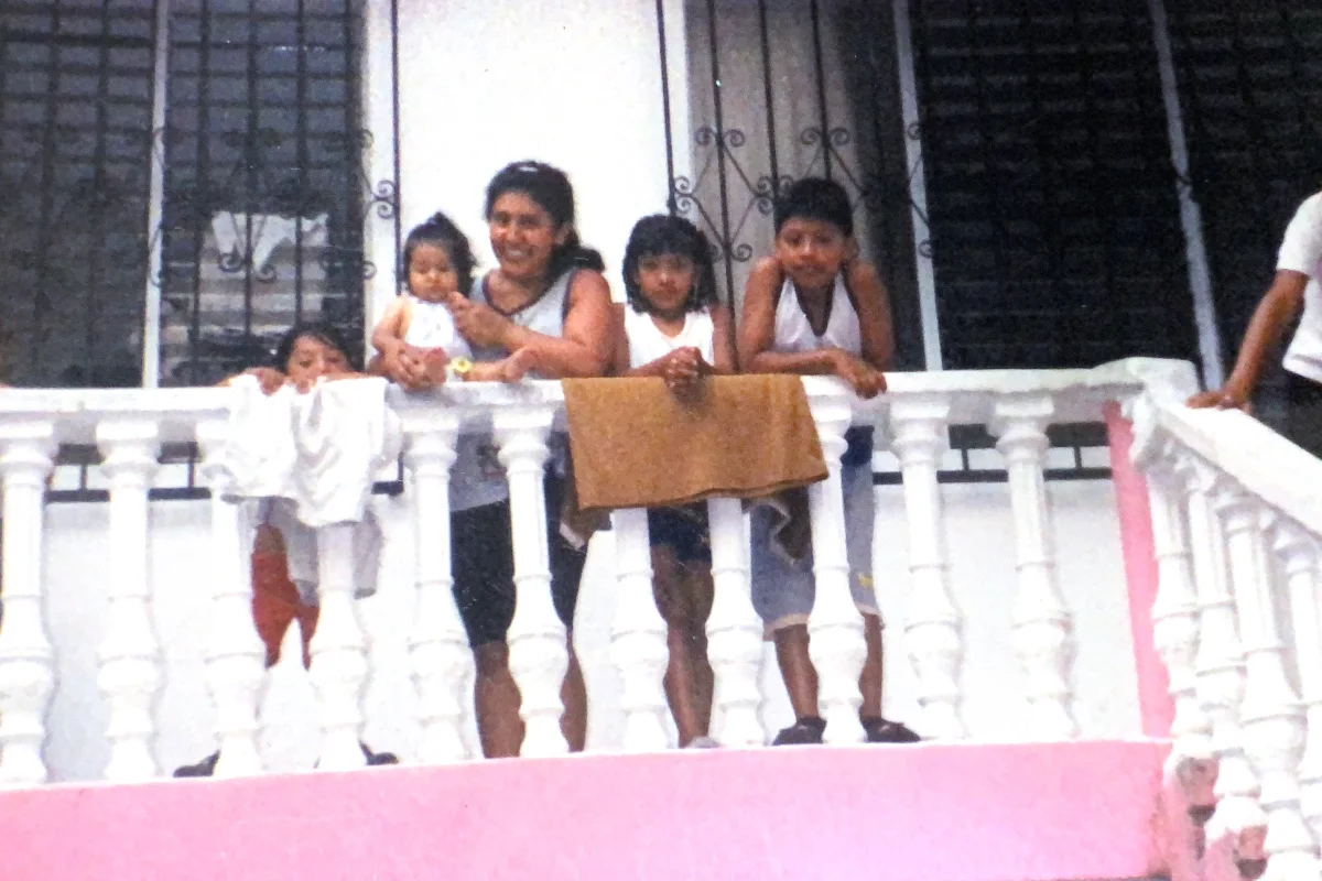 Una mujer posa junto con su cuatro hijos en el barandal de una escalera