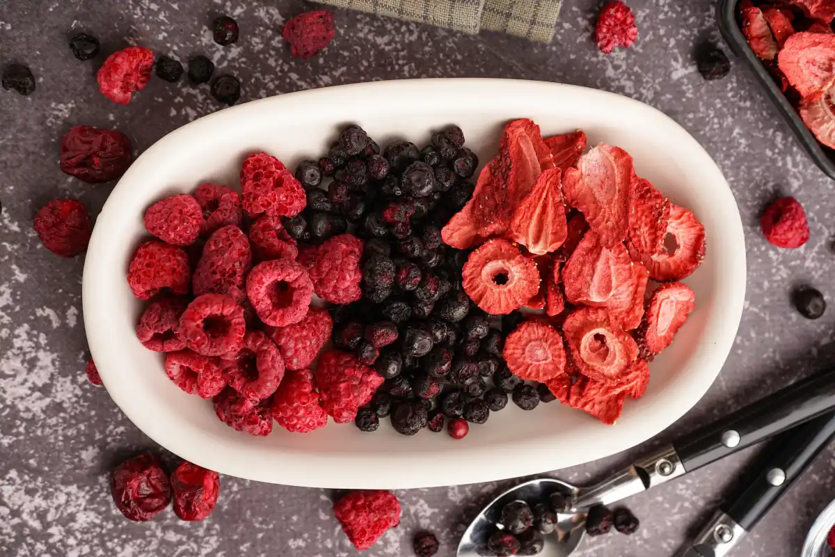 Bowl con frutos rojos liofilizados sobre fondo gris.