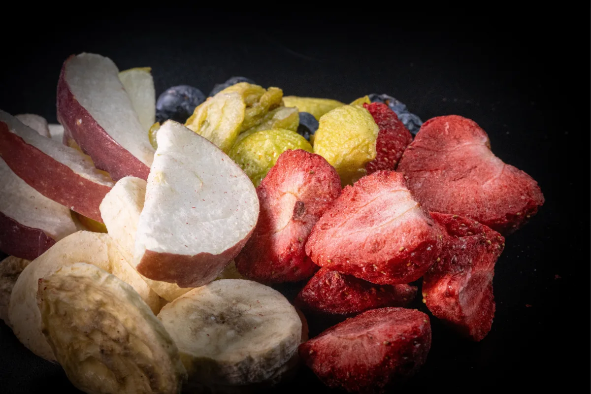 Fruta liofilizada, incluyendo rodajas de manzana, fresas y melocotones.