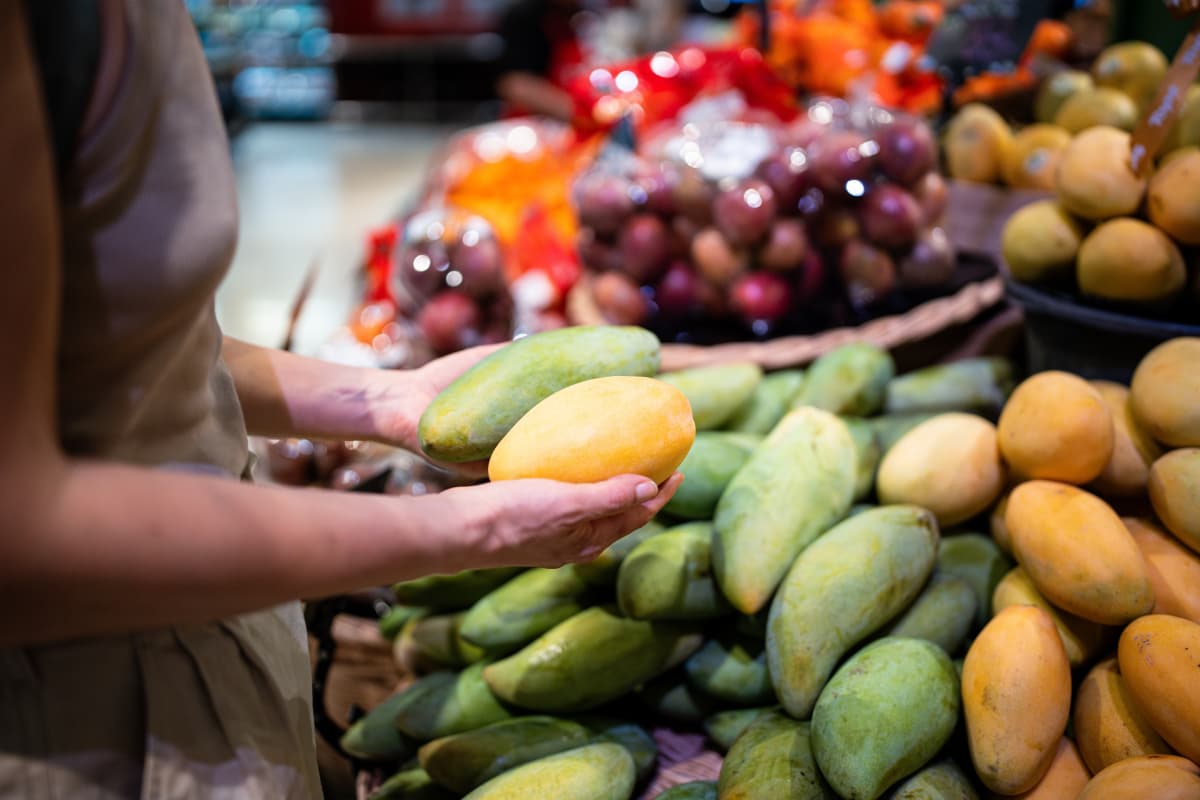 Variedad de mangos en supermercado para venta. 
